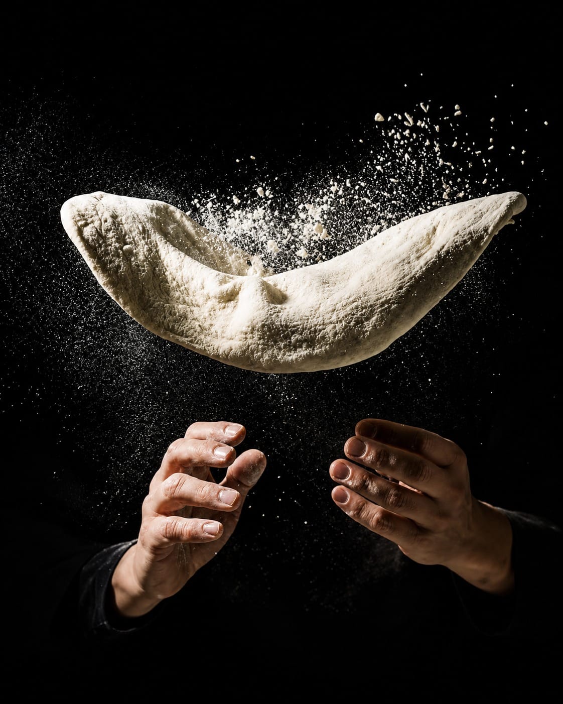 Le mani di Tommaso, pizzaiolo e proprietario di Timilia, lanciano l'impasto tra la farina